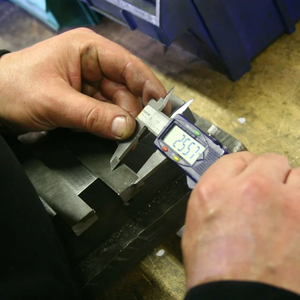 Digital caliper measuring a machined part