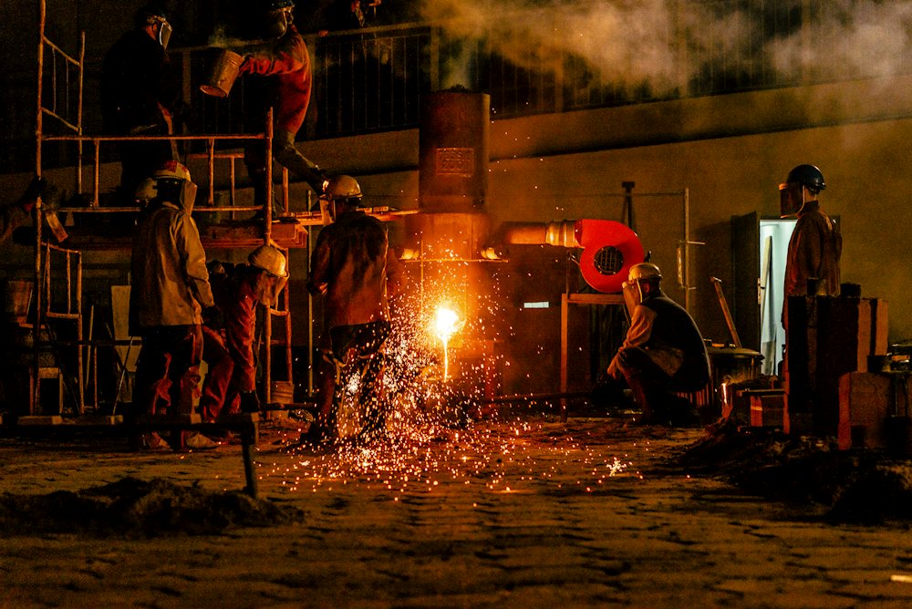 Foundry crew beside a stream of molten metal